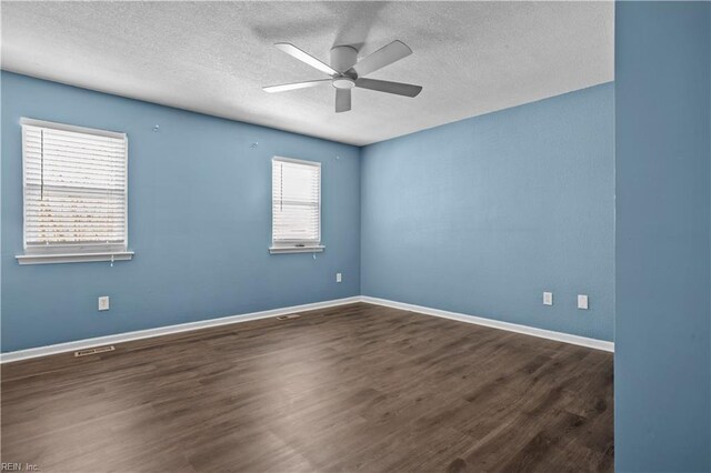spare room featuring baseboards, a textured ceiling, wood finished floors, and a ceiling fan