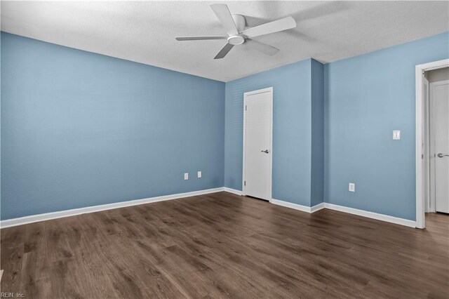 spare room featuring baseboards, a ceiling fan, a textured ceiling, and dark wood-style flooring