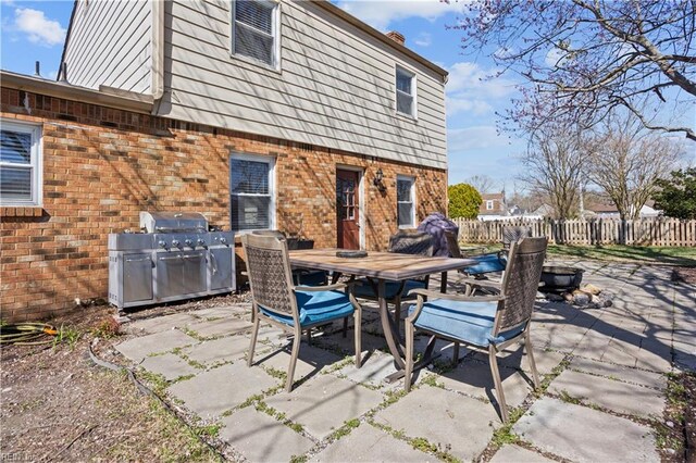 view of patio with grilling area, fence, and outdoor dining space