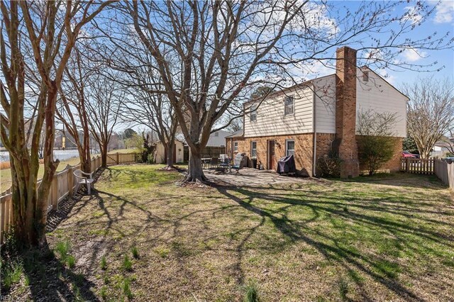 view of yard featuring an outdoor structure, a fenced backyard, a storage unit, and a patio