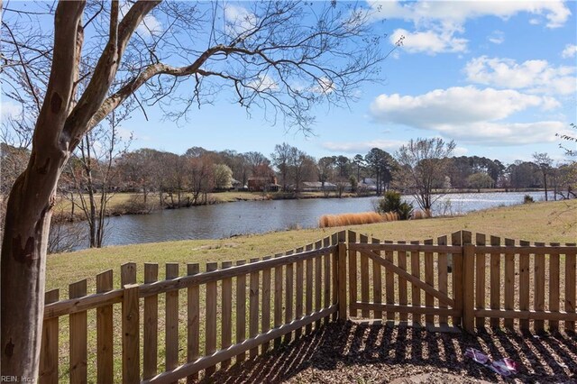 exterior space with a yard, a water view, and fence