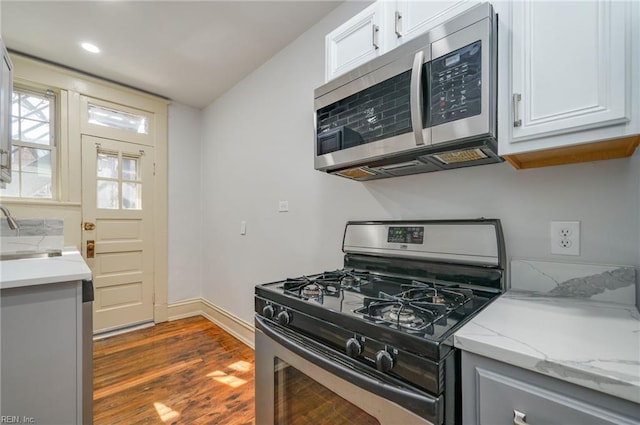 911 Spotswood Ave Unit 6, Norfolk, VA 23517 - kitchen with appliances with stainless steel finishes, dark wood-type flooring, light stone counters, a sink, and baseboards