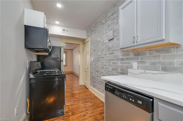 911 Spotswood Ave Unit 6, Norfolk, VA 23517 - kitchen with appliances with stainless steel finishes, dark wood finished floors, tasteful backsplash, light stone counters, and baseboards