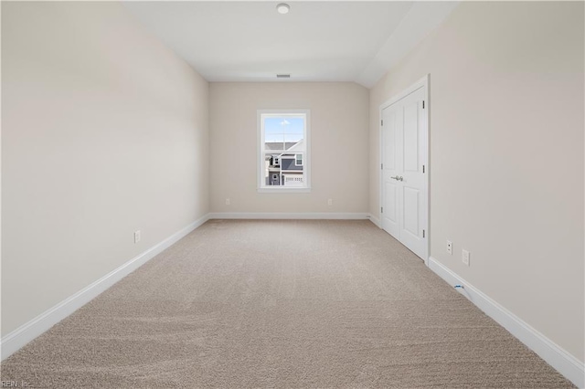 empty room with baseboards, visible vents, and light carpet