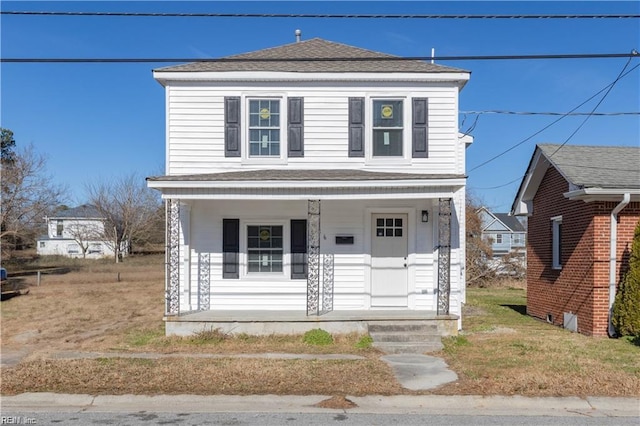 american foursquare style home featuring covered porch and a shingled roof