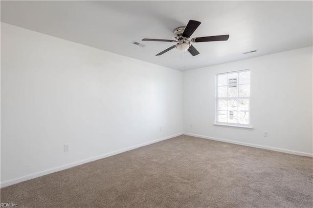 carpeted empty room featuring baseboards, ceiling fan, and visible vents