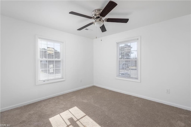 carpeted empty room featuring baseboards, a ceiling fan, and a healthy amount of sunlight