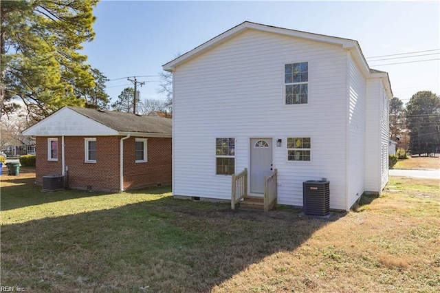 rear view of property featuring a lawn, cooling unit, crawl space, and entry steps