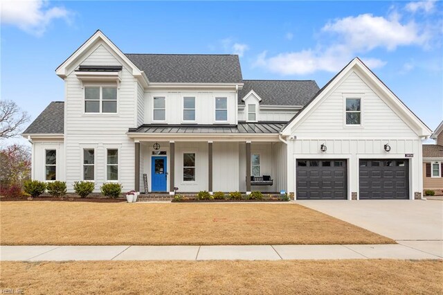 modern farmhouse style home featuring a standing seam roof, metal roof, board and batten siding, driveway, and a porch