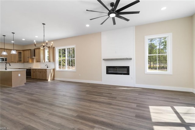 unfurnished living room featuring baseboards, recessed lighting, dark wood-type flooring, and a large fireplace