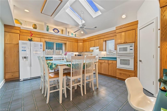 832 Surfside Ave, Virginia Beach, VA 23451 - kitchen featuring white appliances, lofted ceiling with skylight, under cabinet range hood, visible vents, and ceiling fan