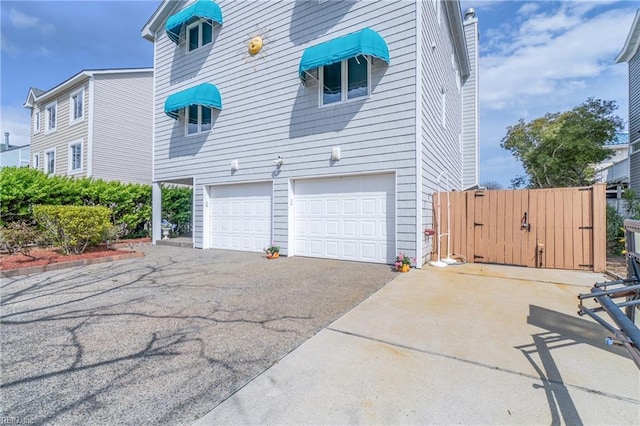 832 Surfside Ave, Virginia Beach, VA 23451 - view of side of home featuring driveway, a gate, and a garage