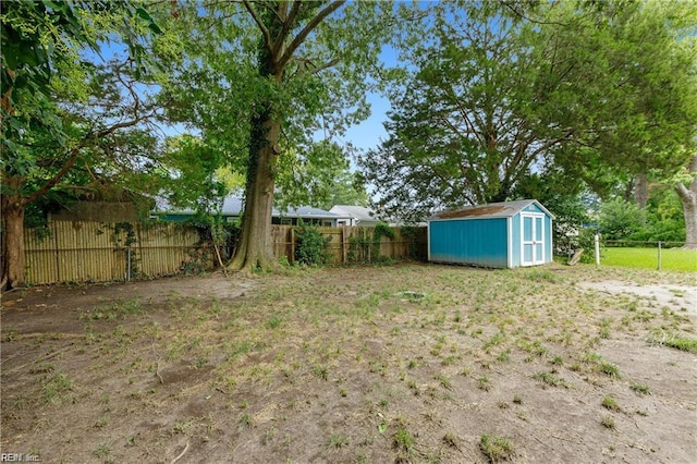 view of yard with a storage unit, a fenced backyard, and an outdoor structure