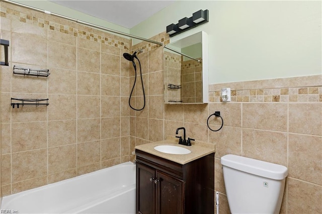bathroom featuring toilet, vanity, tile walls, and washtub / shower combination