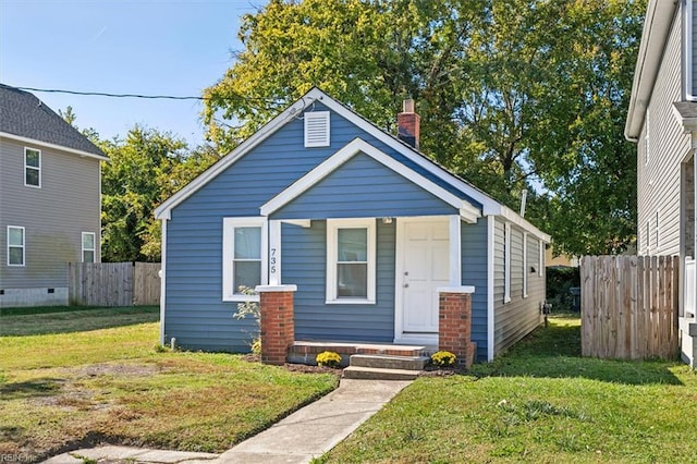 bungalow-style house with a chimney, fence, and a front yard