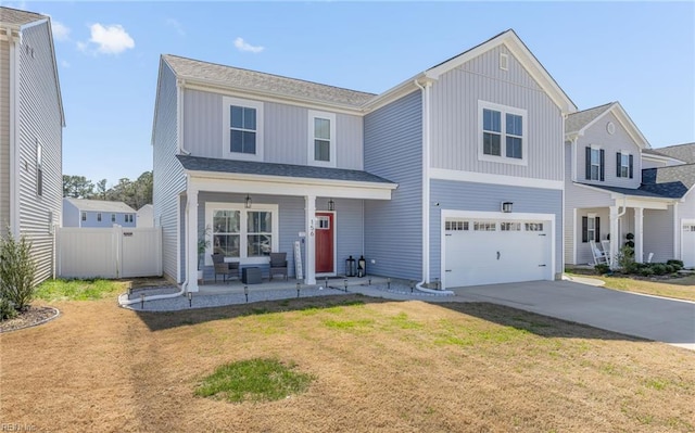 traditional-style house with driveway, a front yard, fence, an attached garage, and a porch