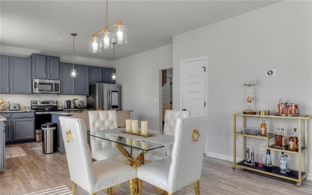 dining space with baseboards and light wood finished floors