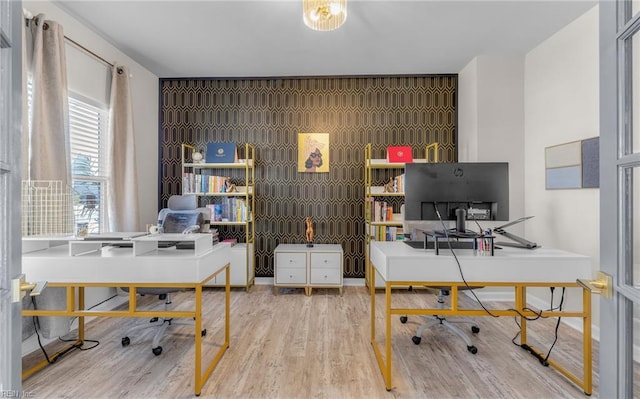 office space featuring an accent wall and wood finished floors