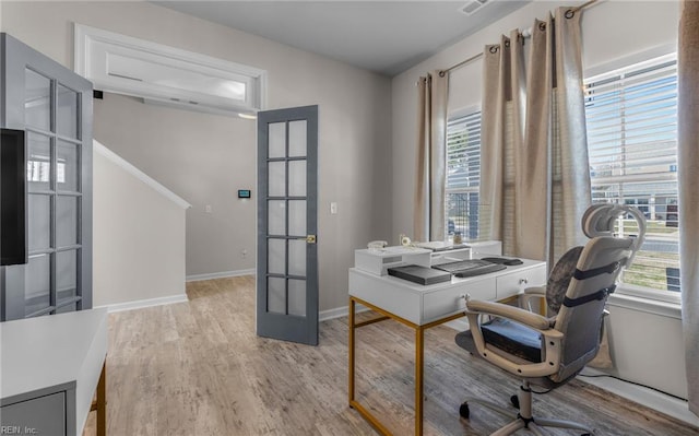 office space with baseboards, french doors, and light wood finished floors