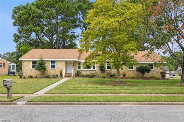 single story home with a front yard and brick siding