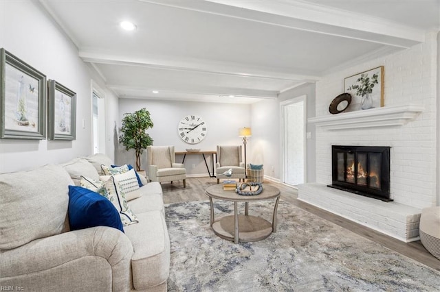 living room featuring baseboards, beamed ceiling, wood finished floors, and a fireplace