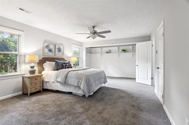 carpeted bedroom with baseboards, visible vents, and a ceiling fan
