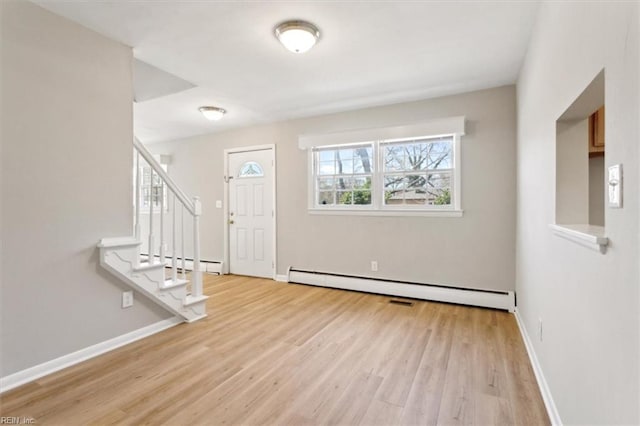 entryway featuring stairs, wood finished floors, a baseboard heating unit, and baseboards