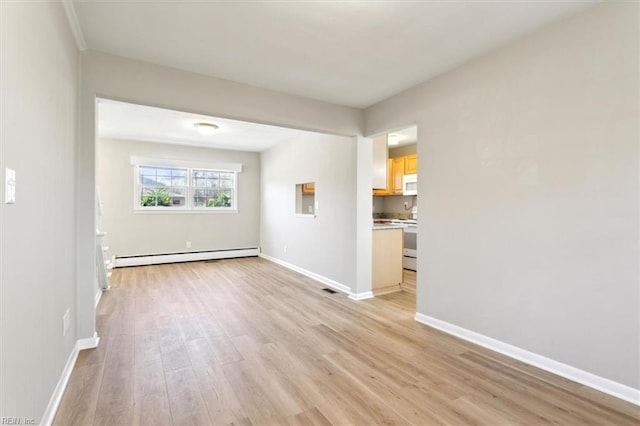empty room featuring a baseboard radiator, light wood-style floors, and baseboards