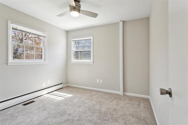 carpeted spare room with baseboards, visible vents, a baseboard heating unit, and a ceiling fan