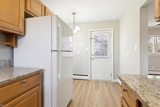 kitchen with a baseboard radiator, a baseboard heating unit, light wood finished floors, freestanding refrigerator, and light stone countertops