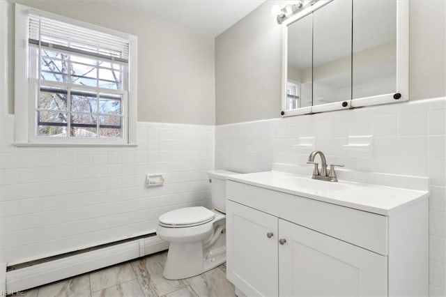 bathroom featuring tile walls, a baseboard radiator, toilet, vanity, and wainscoting
