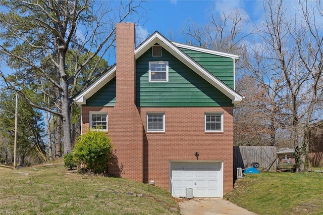 view of side of property featuring driveway, a garage, brick siding, and a yard