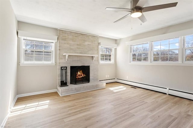 unfurnished living room featuring ceiling fan, baseboards, a fireplace, and wood finished floors