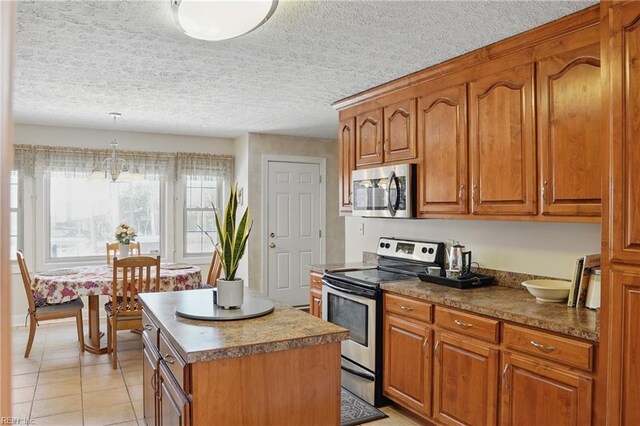 421 Richneck Rd, Newport News, VA 23608 - kitchen featuring light tile patterned floors, brown cabinets, stainless steel appliances, and a kitchen island