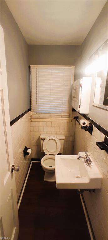 1116 Faubus Dr, Newport News, VA 23605 - bathroom featuring toilet, a sink, tile walls, and wainscoting
