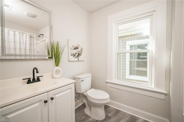 full bathroom featuring visible vents, baseboards, toilet, wood finished floors, and vanity