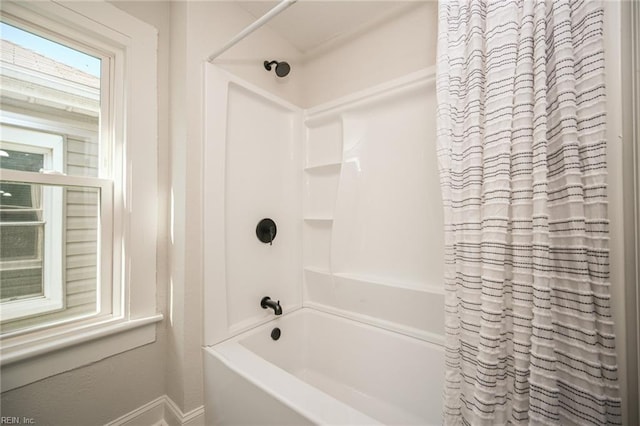 bathroom featuring baseboards and shower / bathtub combination with curtain