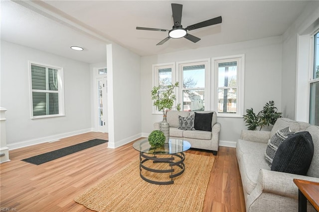 living room with baseboards, ceiling fan, and wood finished floors