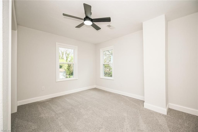 empty room with baseboards, visible vents, ceiling fan, and carpet flooring