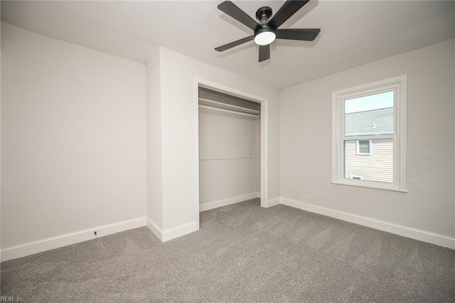 unfurnished bedroom with baseboards, carpet floors, ceiling fan, and a closet