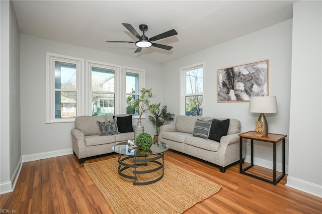 living room with baseboards, wood finished floors, and a ceiling fan