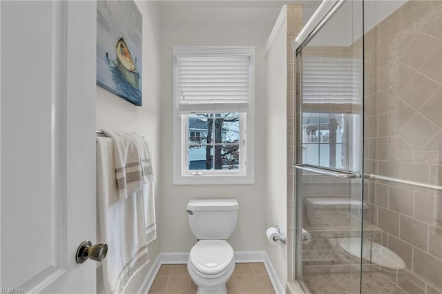 full bath featuring toilet, a stall shower, tile patterned flooring, and baseboards