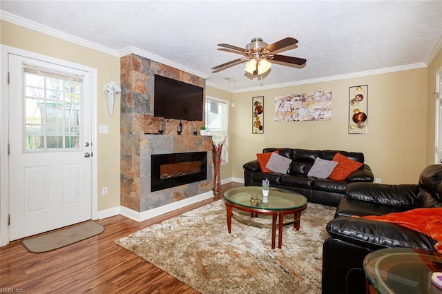 living room with wood finished floors, ornamental molding, and a healthy amount of sunlight