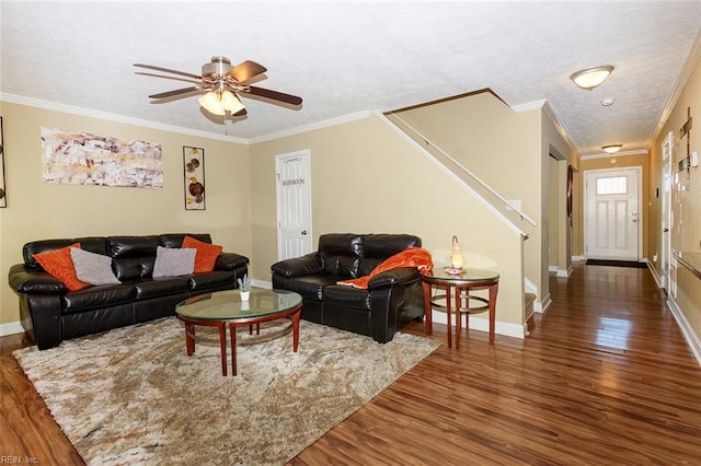 living area featuring ornamental molding, a textured ceiling, stairway, and wood finished floors