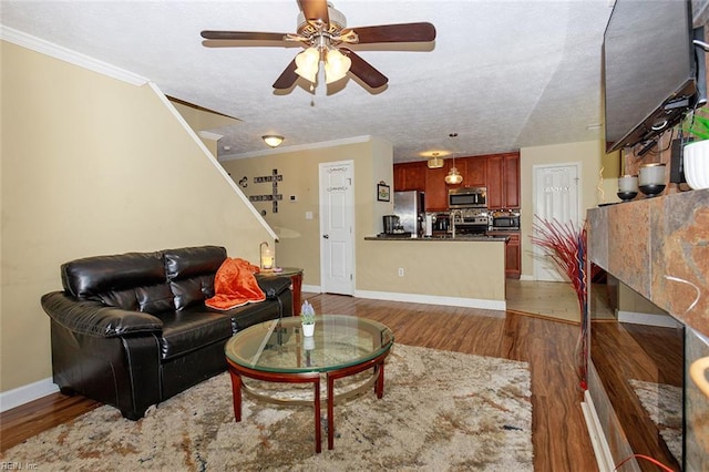 living area with crown molding, stairway, wood finished floors, a textured ceiling, and ceiling fan
