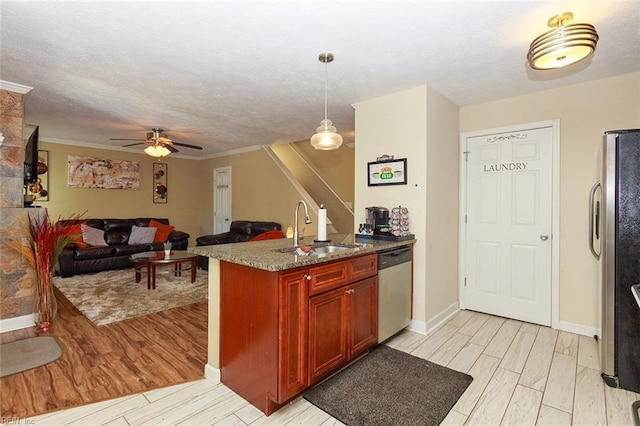 kitchen with light wood-type flooring, stainless steel appliances, a textured ceiling, a sink, and reddish brown cabinets