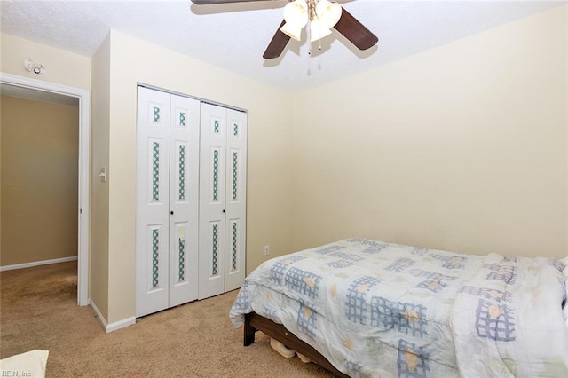 bedroom featuring a ceiling fan, carpet floors, baseboards, and a closet
