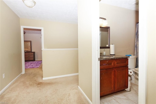 full bathroom with baseboards, a textured ceiling, toilet, and vanity