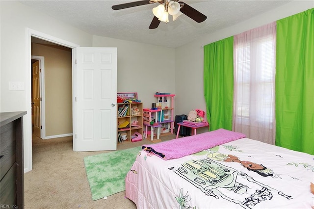 carpeted bedroom with baseboards, ceiling fan, and a textured ceiling