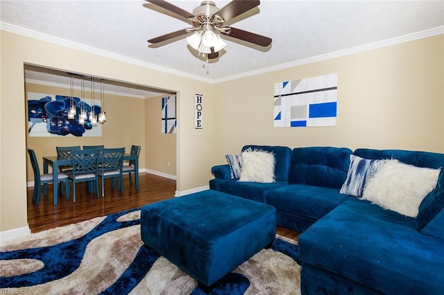 living room with ornamental molding, baseboards, and wood finished floors